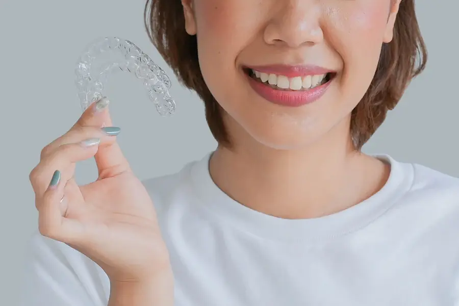 A patient holding a clear aligner tray